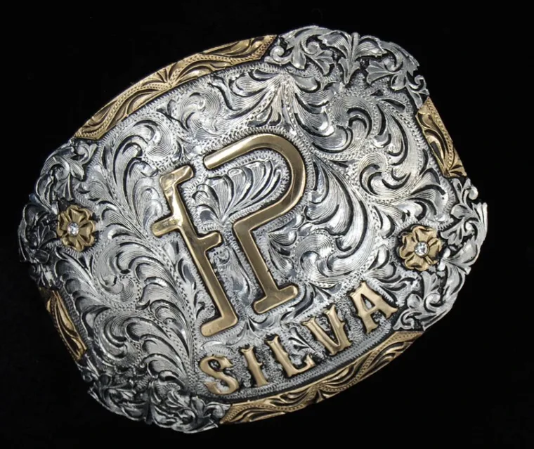 Hebilla grabada con inicial P y apellido Silva, plata y oro